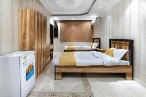 1 dormitorio con 2 camas y nevera en درب البحر, en Yeda
