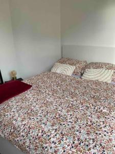 1 dormitorio con 2 camas con colcha de flores en Appartement cozy - Centre ville - 10 min Paris, en Levallois-Perret