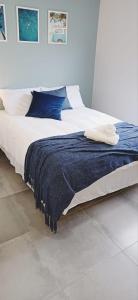 - un lit avec une couverture bleue dans l'établissement Shades of Blue, à Mossel Bay