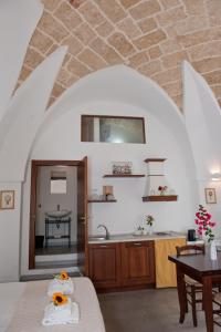 a kitchen and living room with a table and a sink at La Corte Della Luce in Ugento