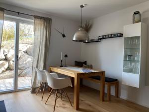 une salle à manger avec une table en bois et des chaises blanches dans l'établissement Ferienwohnung Gschwendt, à Miesbach