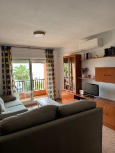 salon z kanapą i telewizorem w obiekcie Apartamento Roquetas playa con WIFI w mieście Roquetas de Mar