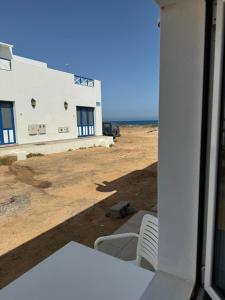 vistas a un edificio con sillas y al océano en Apartamento Chapaleta, en Caleta de Sebo