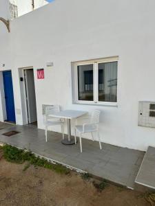 una mesa blanca y sillas junto a una ventana en Apartamento Chapaleta, en Caleta de Sebo