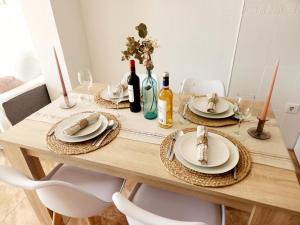 una mesa de comedor con platos y botellas de vino en Apartamento Rincón del Mar, en Cartagena