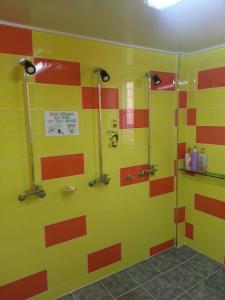 łazienka z żółtymi i pomarańczowymi paskami na ścianie w obiekcie Gyeongju Friend Guesthouse w mieście Gyeongju