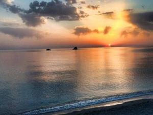 una puesta de sol sobre el océano con una playa en Hotel Ristorante Santa Maria, en Amantea