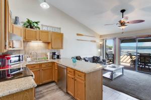 a kitchen with wooden cabinets and a living room at Tommy's Place with 27 Boat Slip and Lift in Osage Beach