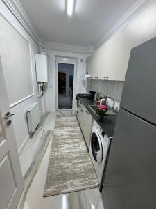 a white kitchen with a washer and dryer in it at Ares Residence in Iaşi