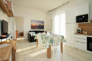 uma sala de estar com uma mesa de jantar e uma sala de estar em Brezza di Sale Appartamenti em Albenga