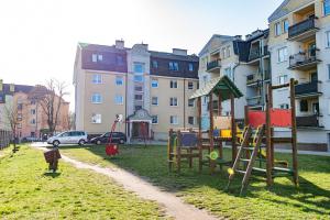 a playground in a park in front of a building at Apartament Wiosenny in Szczecinek