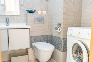 a bathroom with a toilet and a washing machine at Apartament Wiosenny in Szczecinek