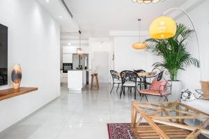 sala de estar con mesa y sillas en Luxury Flat with Balcony & Ocean View by torohome en Ashdod