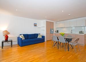 ロンドンにあるCosy Apartment in Central Londonのリビングルーム(青いソファ、テーブル付)