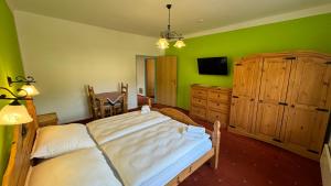 a bedroom with a large bed and a green wall at Penzion Janoštík in Rožnov pod Radhoštěm