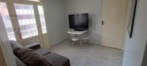 a living room with a couch and a flat screen tv at Riacho Fundo 1 - Riacho Mall in Brasília +8 photos
