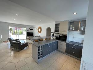 a large kitchen with a counter and a living room at Cap Ras in Empuriabrava