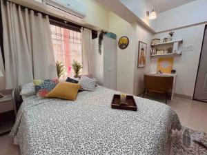 a bedroom with a large bed and a desk at Dawn - A Spacious Modern Studio in Bandra at Almeida Park by Connekt Homes in Mumbai