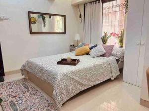 a bedroom with a bed with a tray on it at Dawn - A Spacious Modern Studio in Bandra at Almeida Park by Connekt Homes in Mumbai
