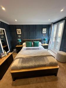 una camera da letto con un grande letto con pareti blu di Rosehall Hotel a Edimburgo