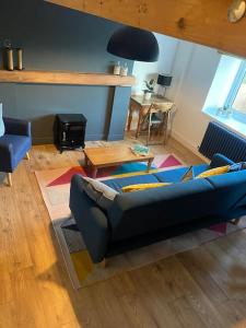 a living room with a blue couch and a table at Pretty little cottage in the peaks in Hadfield