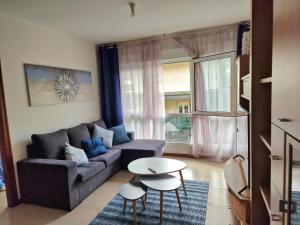 ein Wohnzimmer mit einem Sofa und einem Tisch in der Unterkunft Lovely Blue Moaña in Moaña