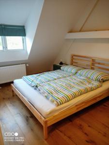 a bedroom with a large bed with a wooden floor at Gemütliche Premium Öko Ferienwohnung in Resthof, super ausgestattet, keine Handwerker und Monteure in Sterley