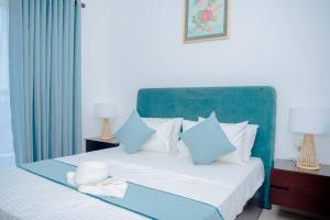 a bedroom with a bed with blue and white pillows at Apartment -Piliyandala Kahathuduwa in Gonapola