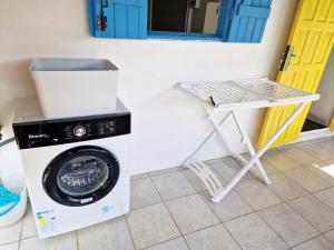 uma máquina de lavar roupa e uma mesa num quarto em appartement T2 avec jacuzzi em Baie-Mahault