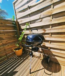 a grill sitting on a deck next to a fence at appartement T2 avec jacuzzi in Baie-Mahault