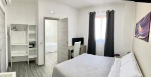 a white bedroom with a bed and a bathroom at Guest house LangAmore in Bra