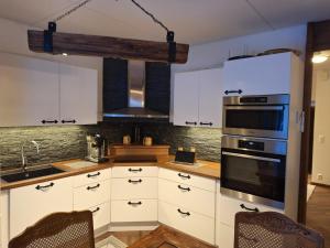 a kitchen with white cabinets and a stove top oven at Villa Lumia in Paranen