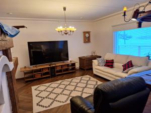 a living room with a television and a couch at Villa Lumia in Paranen