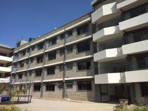 un edificio de apartamentos con un aro de baloncesto delante de él en Lysak Haven Park hotel, en Machakos