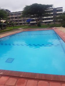 a large swimming pool with blue water in front of a building at Lysak Haven Park hotel in Machakos