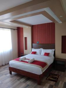 a bedroom with a large bed with red walls at Lysak Haven Park hotel in Machakos