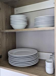 a stack of plates and bowls on a shelf at 3 Bedroom Heaven Home ll Summerhouse in Hastings