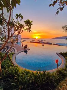una piscina con il tramonto sullo sfondo di Covesign Suite a Kota Kinabalu