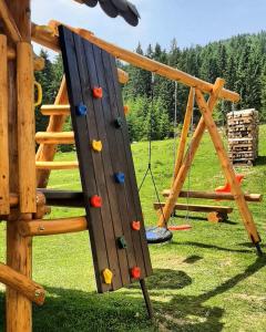 a playground with a rock wall and a swing at CABANA FRAM VÂRTOP in Nucet