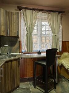 a kitchen with a chair and a sink and a window at Chata Nemcová - Muránska planina in Muráň