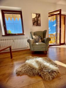 sala de estar con silla y alfombra de piel en Apartment KIMO - stunning view of High Tatras en Veľká Lomnica