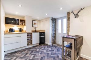 a kitchen with white cabinets and a table in it at The Holt - Ilkley, central location, stylish apartment in Middleton
