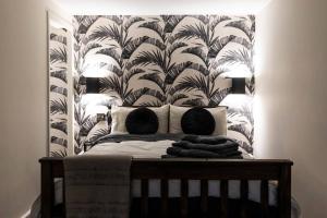 a bedroom with a bed with a headboard with a wallpaper at The Holt - Ilkley, central location, stylish apartment in Middleton