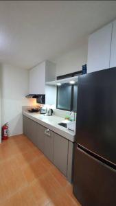 eine Küche mit einem schwarzen Kühlschrank und einer Spüle in der Unterkunft MetroStay Oasis in Cebu City