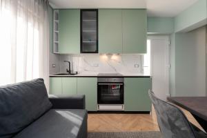 ヴルサルにあるLarum Apartmensの白いキャビネット、ソファ、テーブル付きのキッチンが備わります。