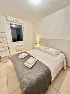 een slaapkamer met een bed met twee handdoeken erop bij T3 Georges Beljean - DABNB in Limoges