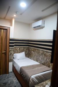a small bedroom with a bed and a window at THE KINGSLEY La -PRIMA CASA HOTEL in Lagos