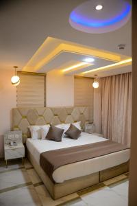 een slaapkamer met een groot bed en een blauw plafond bij THE KINGSLEY La -PRIMA CASA HOTEL in Lagos