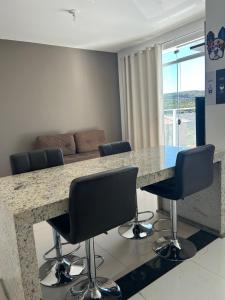 a kitchen with a table with chairs and a couch at Apartamento inteiro com garagem em Diamantina/MG in Diamantina
