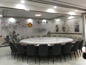 ダル・エス・サラームにあるFASHION INTERNATIONAL HOTELの円形のテーブルと椅子が備わる広い客室です。
